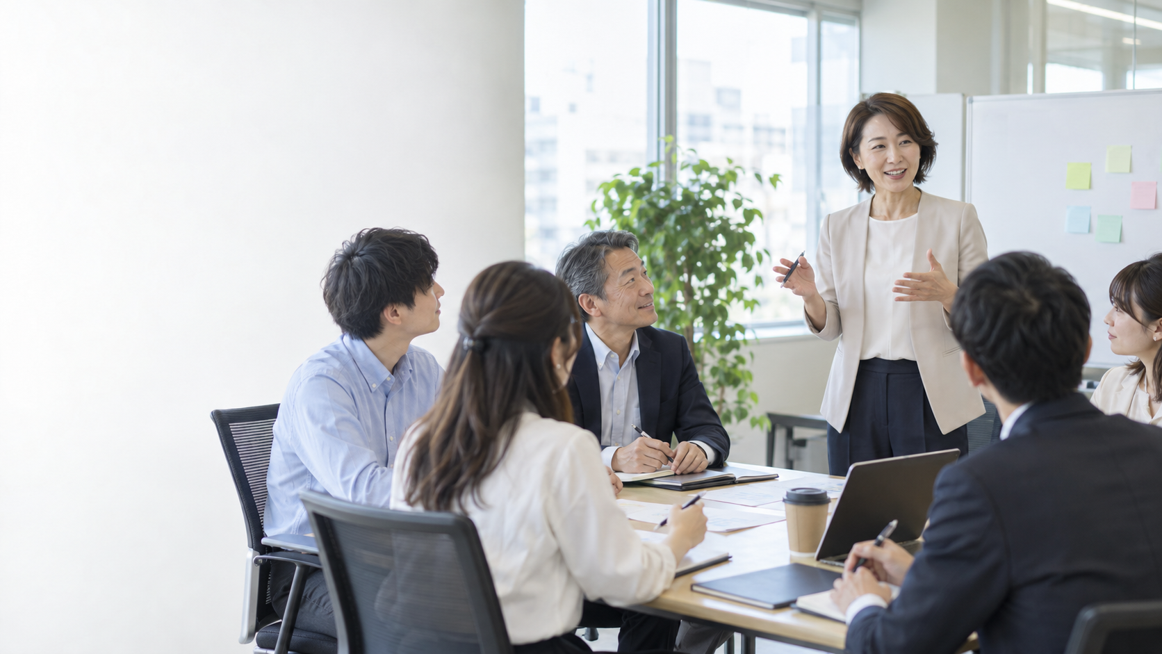 日本企業の研修会場で受講者と対話する研修担当者