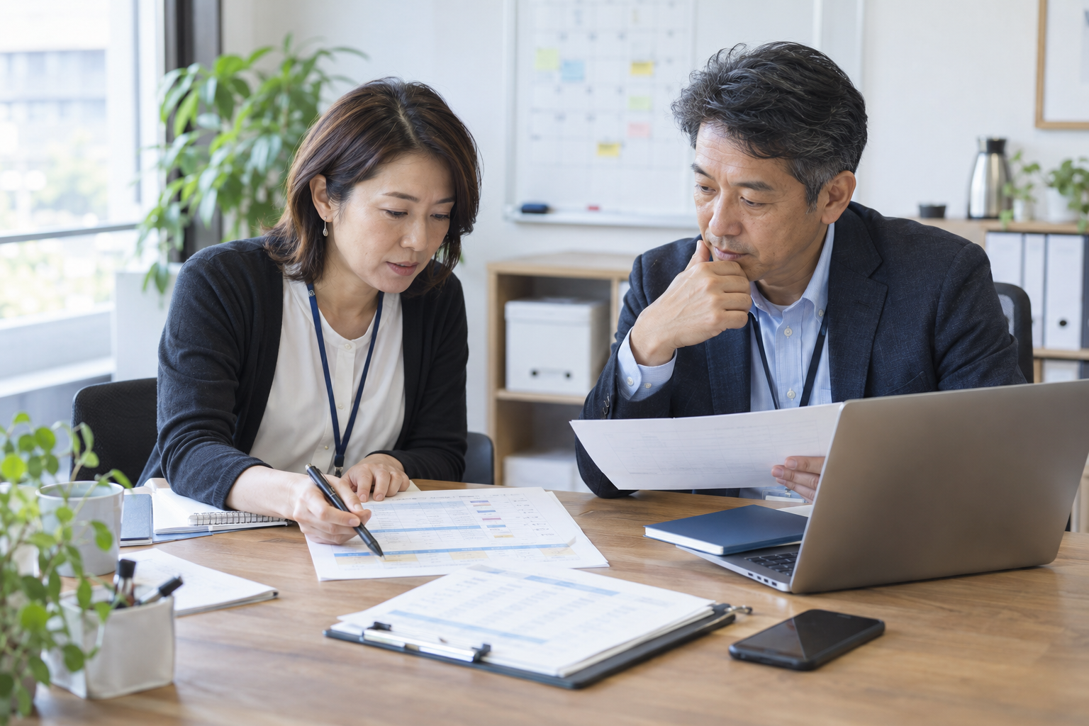 開催日程と参加者の案内を確認する日本人運営担当者